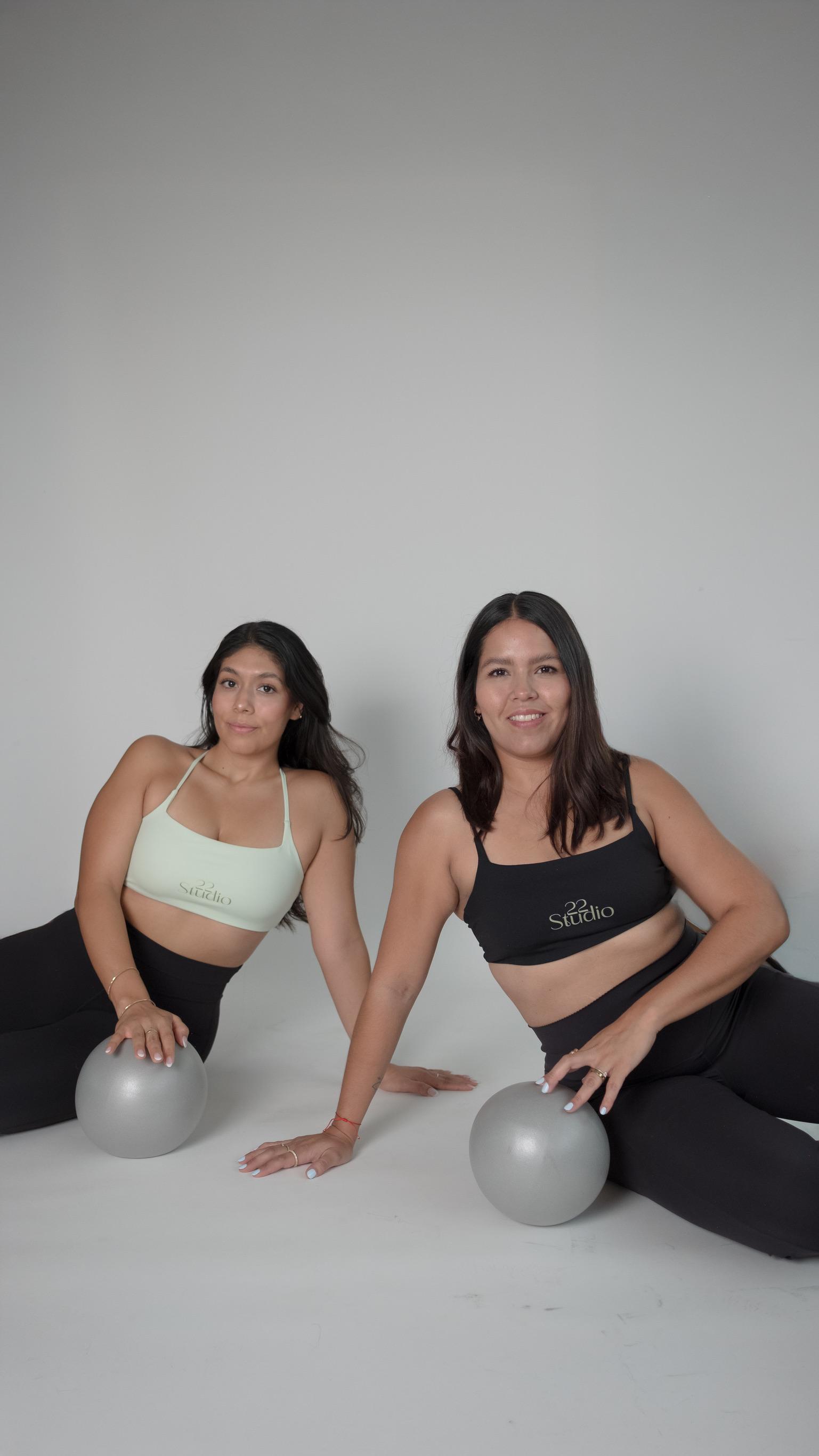 Dos coaches sonriendo con pelotas de pilates